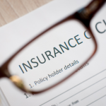 Close-up of an insurance claim form viewed through eyeglasses, symbolizing attention to detail and customer experience in insurance claims processing